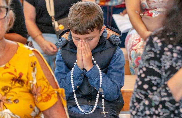Inácio, de sete anos, filho de Juliano Cazarré, emociona ao rezar o terço em cerimônia no Rio de Janeiro